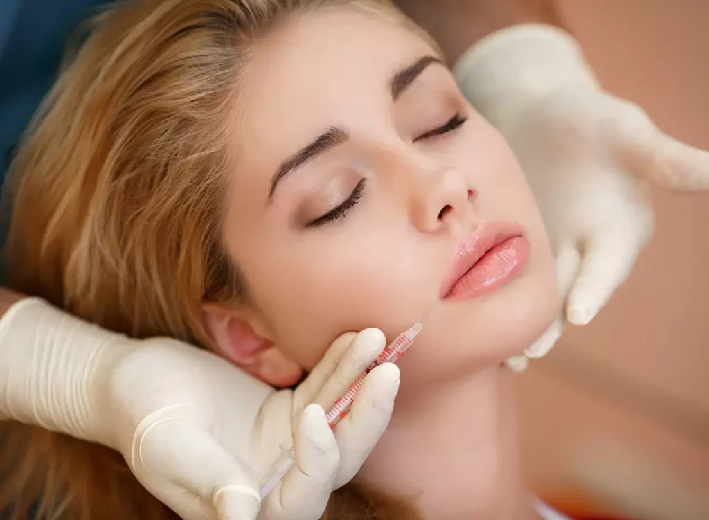 Lip dermal filler treatment procedure with cosmetic injector applying hyaluronic acid filler to enhance lip volume and shape.